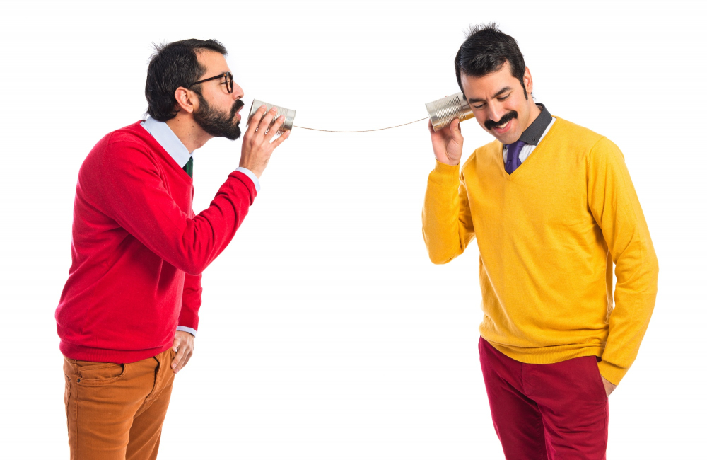 Un homme qui communique avec un autre à l'aide d'une conserve attachée à une autre par un file.